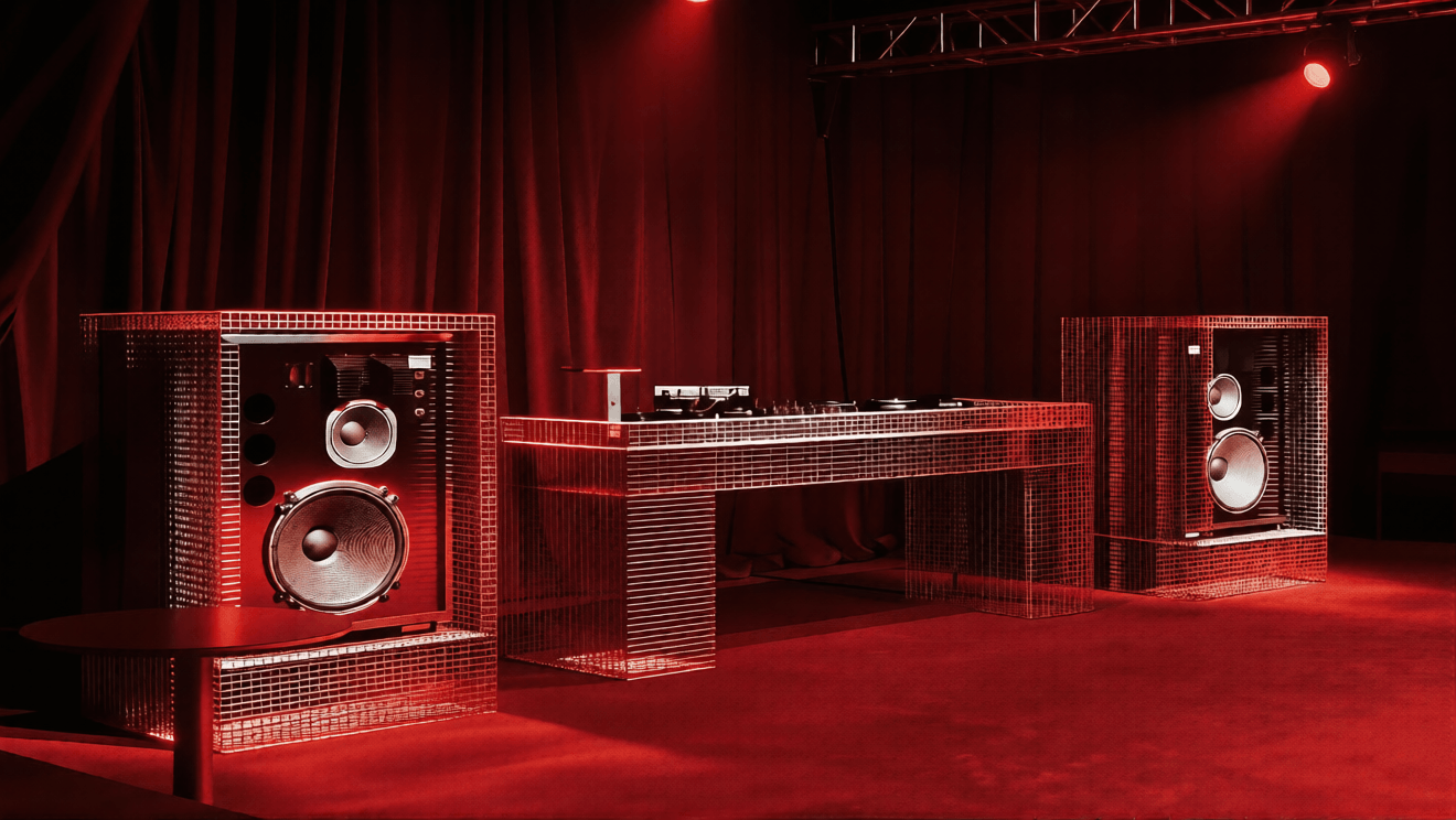 Professional DJ setup with mirrored speakers and turntable on red-lit stage with dramatic dramatic curtain backdrop